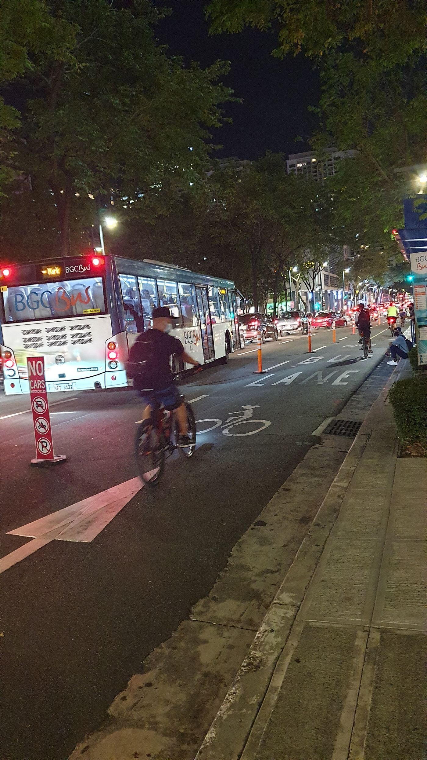 Cyclists ride safely along a protected bike lane separated from car traffic.